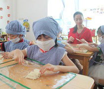 在大愛媽媽及老師的引導下，小朋友學習如何包餃子。【攝影者：許證勝（濟韡）】