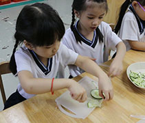 小朋友在老師的協助下，用四種蔬菜，製作創意素食魚生。【攝影者：陳瑞文】