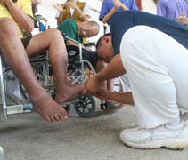 慈濟志工陳智強（本諦）為其中一位長者修剪腳趾甲。【攝影者：何威明】