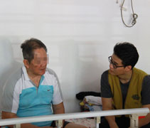 醫學系學生周澤淵在協助看診的同時，也傾聽長者們的心聲。【攝影者：姚惠慧】
