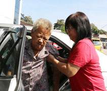 陳秀妹雙腳乏力，蘇美英小心翼翼地攙扶母親下車。【攝影者：董燕榮（慈奐）】