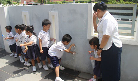 馬來西亞吉打慈濟幼兒園的小朋友在烈日當空下排隊輪流裝水。【攝影者：許證勝（濟韡）】