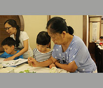 周清彩在水墨畫課堂上擔任小老師，協助沈瑞山老師指導低年級的學員。【攝影者：黃翊晴】