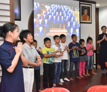 馬來裔小朋友們與慈濟志工們站在台上，一起演繹〈一家人〉手語。【攝影者：林英慷】