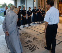 慈濟志工鍾開仿（濟格）為精舍師父們講解環保教育館內入口處的地面設計「走路要輕，怕地會痛」。【攝影者：陳志財（濟庭）】