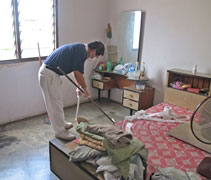 劉炳坤為照顧戶打掃。【攝影者：受訪者提供】