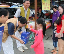 媽媽見志工巴剎在募款，隨即鼓勵女兒去投愛心箱，將善念植入孩子心中。【攝影：陳寶心（慈竹）】