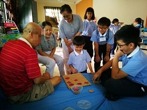 慈幼開心的與療養中心內的老伯玩井字棋游戲，互動頻頻相談甚歡。【攝影者：駱偉庭】