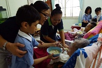 志工讓孩子們替不能自理的長者餵食，讓長者們倍感溫馨。【攝影者：周昌俊】