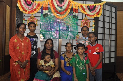 娜瓦瑪尼（後左3）帶著媽媽、妹妹及5名年幼的孩子盛裝出席屠妖節發放活動。【攝影：鄭一宇】