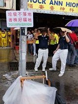 雖遊行期間下起零星小雨，但無阻慈濟志工宣導環保，志工在屋簷下躲雨，待雨停後再繼續向民眾宣導環保。【攝影者：葉俍輝（濟岸）】