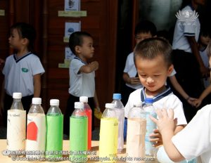 孩子把贴上“坏习惯”的瓶子排列整齐，让下一个小伙伴继续游戏。 （摄影者：邝奕谦）