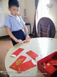 迎接華人農曆新年，高淵慈濟安親班學生，利用回收紅包封，製作新春吊飾。