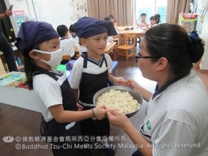 孩子们把炒好的“师太饭”送给四岁班老师，与弟弟妹妹分享自己制作的食物。