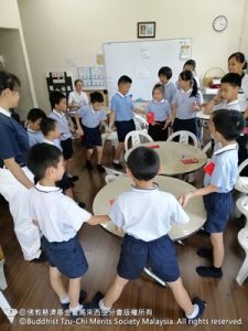 孩子們圍著圓圈，唱著歌並且交換禮物。