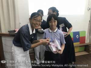 老师与大爱妈妈颁发大奖与蔬果徽章给素食90餐的孩子。