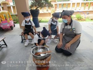 老师在讲解用火炭煮食物需要注意的安全。