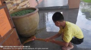 孩子們用餘下的污水清洗地板，不浪費任何資源。