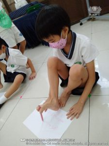 孩子们体验没有了双手，原来用脚来握笔和写字是多么不容易的事呀！