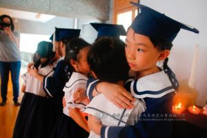 传递心灯后，六岁班的孩子给予弟弟妹妹一个温暖的拥抱，并叮咛他们要把好行为及好习惯传承下去。 （摄影者：黄翊晴）